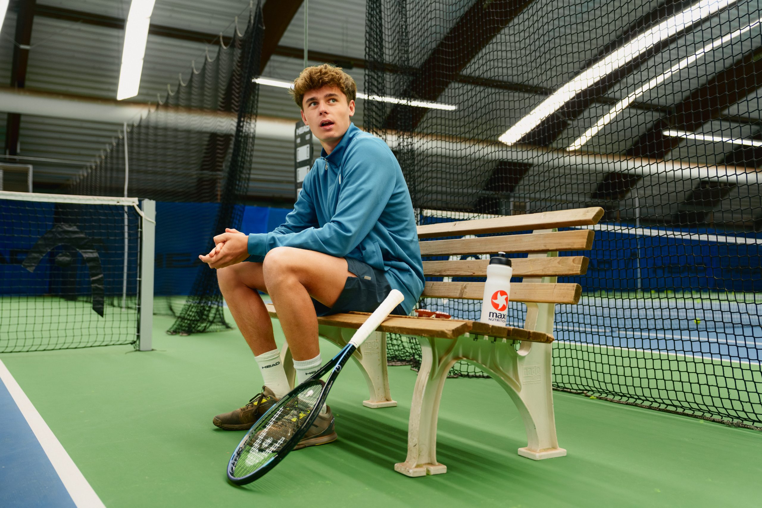 Nico Hipfl sitzt auf einer Bank und bereitet sich auf das nächste Tennis Match vor.