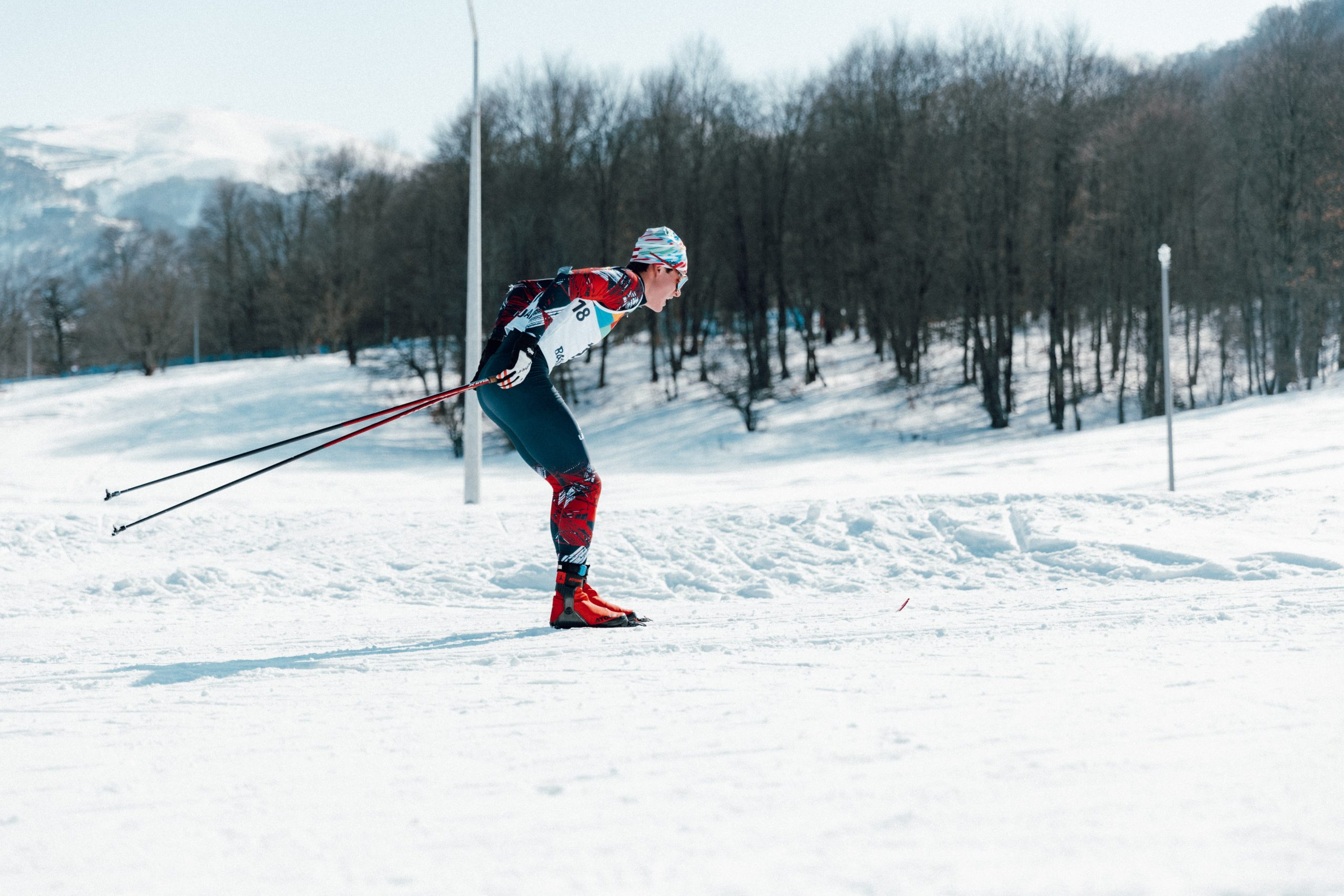 Elias Eischer beim Langlauf Rennen vor einer Schneekulisse.