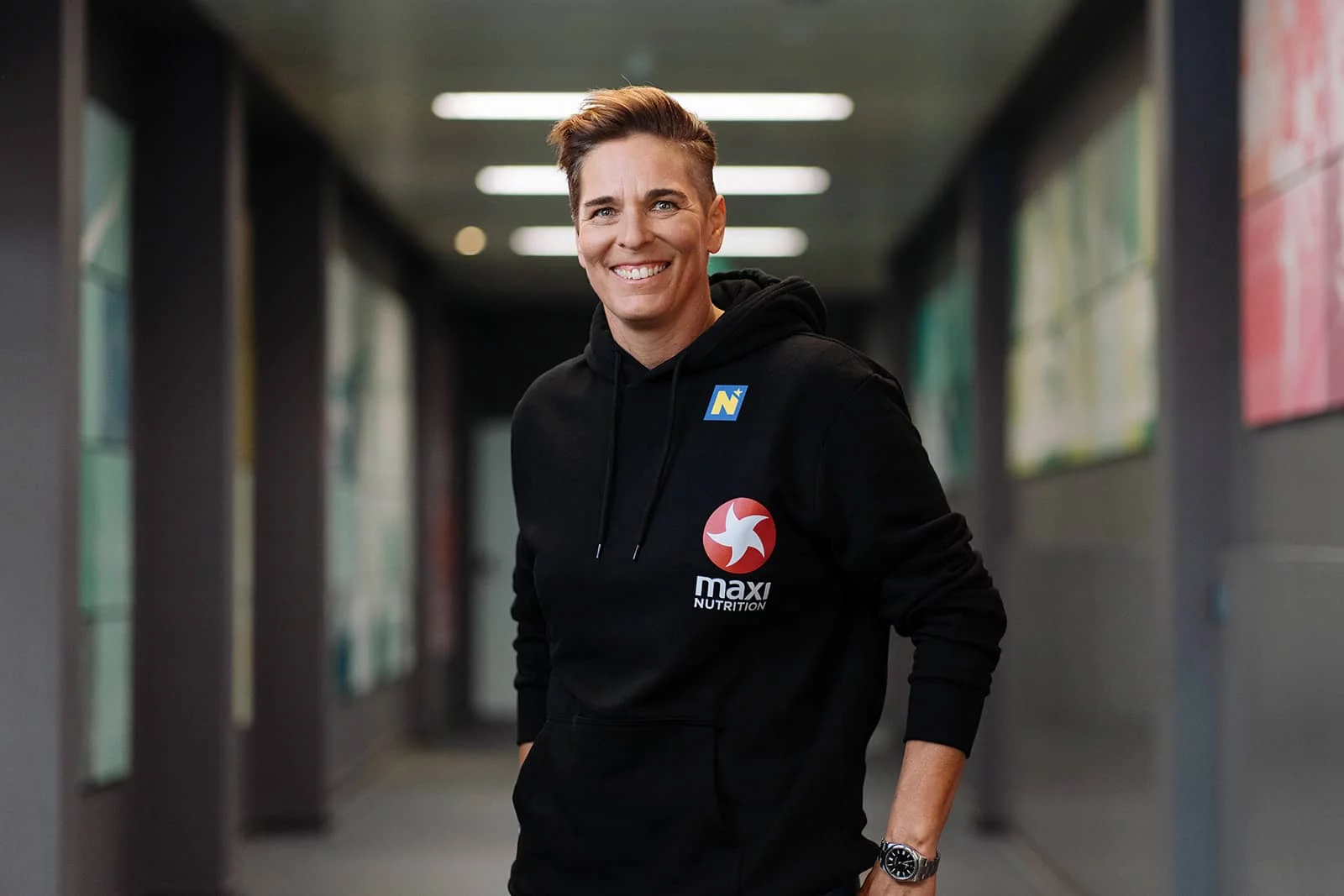 Michaela Dorfmeister lächelnd in einem modernen Hallengang